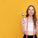 medium-shot-woman-holding-fork-spoon_23-2148996337