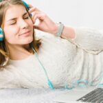 woman-enjoying-music-near-laptop_23-2147801933