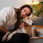 woman-with-greyhound-dog-home-couch_23-2150283069